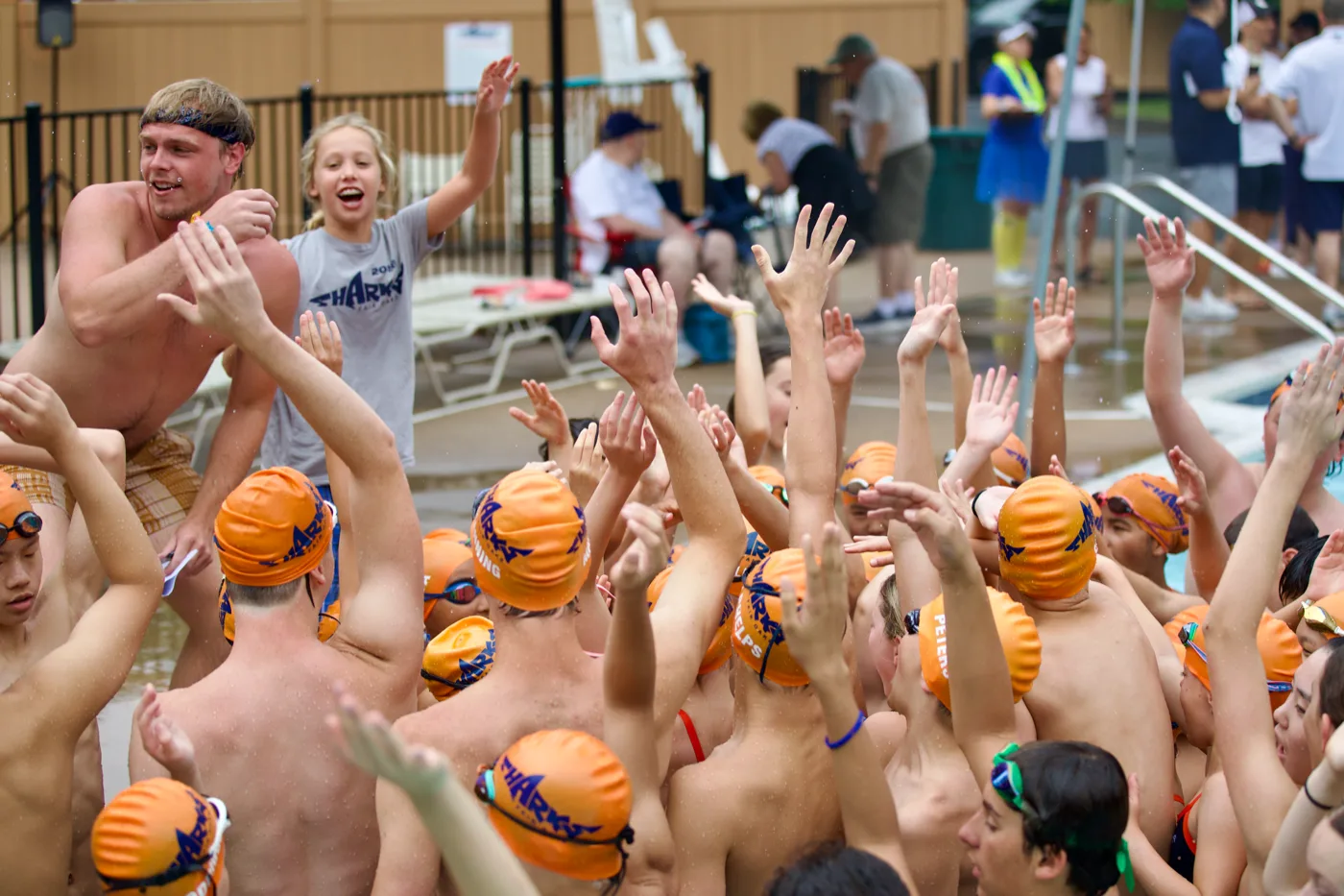 Swim team with hands raised cheering